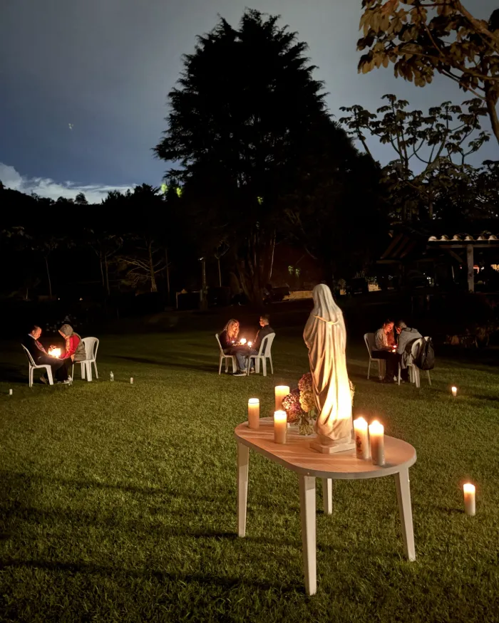 Parejas de novios orando a la luz de las velas junto a una imagen de la Virgen